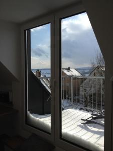 two glass doors with a view of a balcony at Feriendomizil Ösetalblick in Bad Driburg