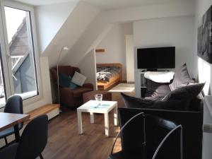 ein Wohnzimmer mit einem Sofa und einem TV in der Unterkunft Feriendomizil Ösetalblick in Bad Driburg