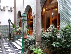 een groene paal voor een gebouw met planten bij Hôtel Transatlantique in Casablanca