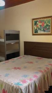 ein Schlafzimmer mit einem Bett und einem Gemälde an der Wand in der Unterkunft Casa para temporada e fins de semana in Itanhaém + 29 Fotos