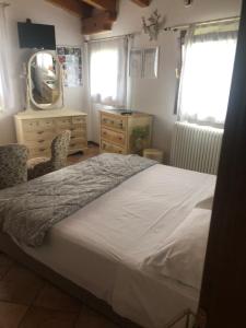 um quarto com uma cama, um espelho e uma cómoda em Country House Salomè em Musile di Piave