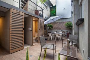 a patio with a table and chairs and an umbrella at Experience México City Condesa, Central Location, Rooftop Terrace, Coworking, Amazing Artistic Place in Mexico City