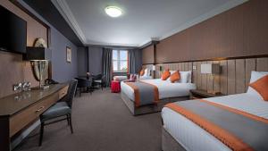 a hotel room with two beds and a desk at Midlands Park Hotel in Portlaoise