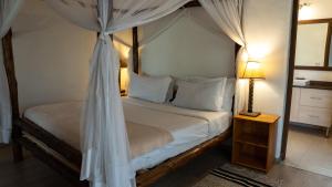 a bedroom with a bed with a canopy at Mountain Ash House in Nakuru