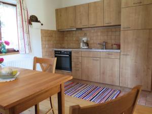 a kitchen with wooden cabinets and a wooden table at Ferienwohnung Aiblinger in Frasdorf +5 photos