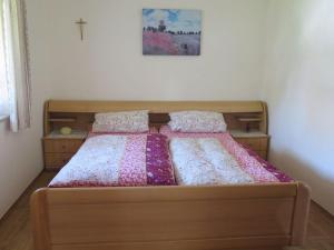 a bed with a wooden frame and pillows on it at Ferienwohnung Aiblinger in Frasdorf
