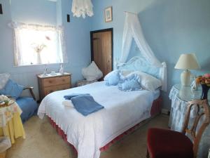 Un dormitorio azul con una cama con un osito de peluche. en East Farm House B&B, en Abbotsbury