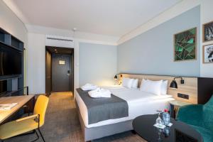 una camera d'albergo con letto, scrivania e divano di Holiday Inn Hasselt, an IHG Hotel a Hasselt