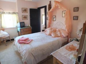 a bedroom with a large white bed with pink sheets at East Farm House B&B in Abbotsbury