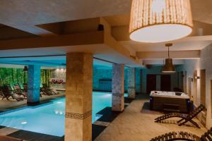 a pool with a table in the middle of a building at Boutique Hotel Cattaleya in Bacău