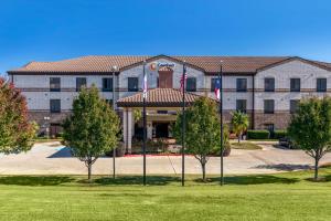 a large building with two flags in front of it at Comfort Suites Marshall in Marshall