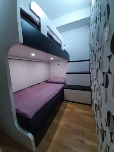 a bedroom with a bunk bed with purple sheets at Diamond Bled in Bled