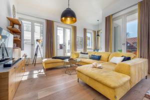 ein Wohnzimmer mit einem gelben Sofa und einem Tisch in der Unterkunft FIRST Avalon in Ostseebad Sellin