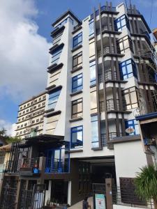 a tall white building with blue windows at Finteo Skylands Premium in Baguio