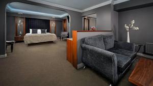 a bedroom with a bed and a couch and a chair at Midlands Park Hotel in Portlaoise