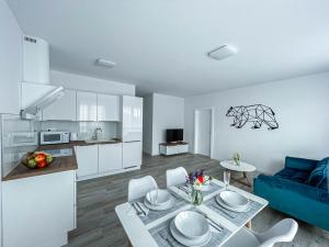 cocina y sala de estar con sofá azul y mesa en LAWIS Apartments en Poprad