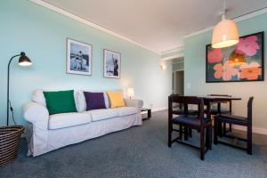 a living room with a white couch and a table at Hotel Apartamento Solverde in Espinho