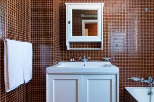 a bathroom with a white sink and a mirror at Hotel Apartamento Solverde in Espinho