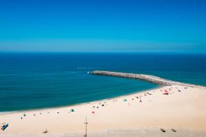 a group of people on a beach near the ocean at Hotel Apartamento Solverde in Espinho