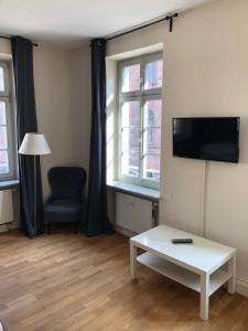 a living room with a tv and a table and a chair at Schlossblick - a62076 in Heidelberg