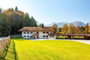 una casa con un gran campo verde delante de ella en Ferienwohnung Staffen, en Unterwossen