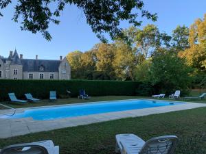 a swimming pool in the yard of a house at l'Abeaupinière in Reboursin