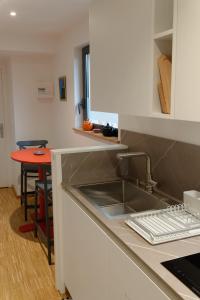 a kitchen with a sink and a counter with a table at Studio Les Terrasses de Kerangall in Brest
