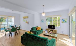 una sala de estar con 2 sofás verdes y una mesa. en Villa Shiva by Ezoria Villas, en Bahía de Coral