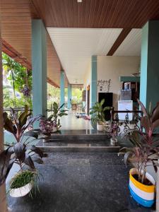 un hall avec des plantes en pot dans un bâtiment dans l'établissement Rutu Enclave, à Murud