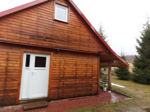 a building with a white door and a window at Apartament Ruska Bania Na Pograniczu in Lasowka