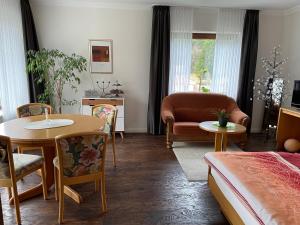 a living room with a bed and a table and chairs at Gästehaus Ute Müller in Wimbach