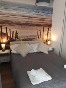a bedroom with a bed with a picture of a beach at Apartament Piaskowy Sunset Resort in Grzybowo
