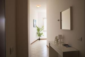 einen Flur mit einem Spiegel und einem Tisch in einem Zimmer in der Unterkunft Cà del Mar in Polignano a Mare
