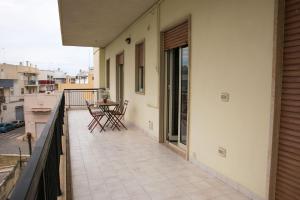 balkon domu ze stołem i krzesłami w obiekcie Cà del Mar w mieście Polignano a Mare