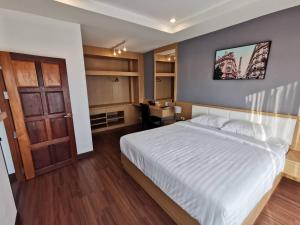 um quarto com uma cama, uma porta e uma secretária em The Cottage Hotel Udon Thani em Ban Bo Nam
