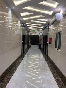um corredor com paredes brancas e um tecto com luzes em Elite Furnished Units em Riyadh