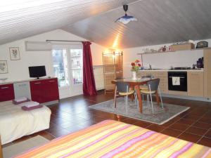 ein Schlafzimmer mit einem Bett und einem Tisch sowie eine Küche in der Unterkunft I Pettirossi in Frabosa Sottana