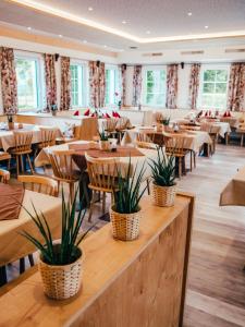 um restaurante com mesas e cadeiras com plantas em Gasthof Franziskibad em Bad Häring