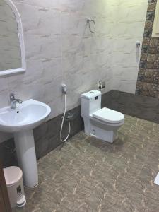 a bathroom with a toilet and a sink at Elite Furnished Units in Riyadh
