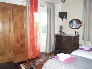 ein Schlafzimmer mit einem Bett, einer Kommode und einem Fenster in der Unterkunft I Pettirossi in Frabosa Sottana