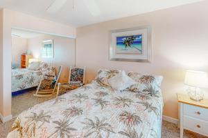 a bedroom with a bed with palm trees on it at Sand Dollar I 301 in Ocean City