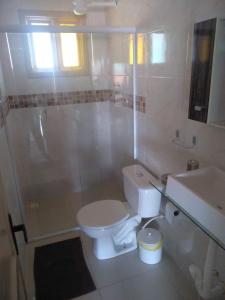 y baño con aseo, ducha y lavamanos. en Casa a 50 mt da Praia., en Bombinhas