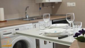 a kitchen with a table with wine glasses and plates at EL CAPRICHO DEL BURGO in El Burgo de Osma +51 photos