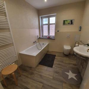 a bathroom with a tub and a toilet and a sink at Fewo Am Marktplatz II in Eisenhüttenstadt