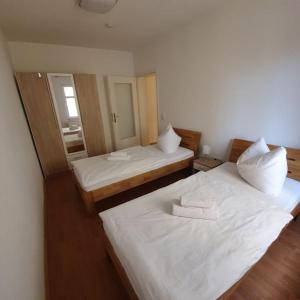 2 camas con sábanas blancas en una habitación en Fewo Am Marktplatz II, en Eisenhüttenstadt