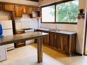 聖維森特的住宿－Casa de Paz，厨房配有木制橱柜、水槽和窗户。