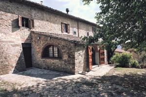 un antiguo edificio de piedra con un garaje delante en Casa Iris Panzano in Chianti, en Pieve di Panzano