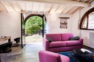 Una sala de estar con un sofá y sillas morados. en Casa Iris Panzano in Chianti, en Pieve di Panzano