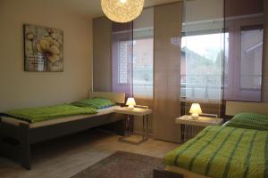 a bedroom with two beds and a window and a chandelier at Dorsten-Ferienwohnung, Hermannstraße in Dorsten