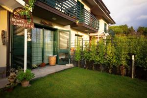 ein Haus mit einer Veranda und einem Garten mit Gras in der Unterkunft B&B Ruota di Carretto in Nicolosi